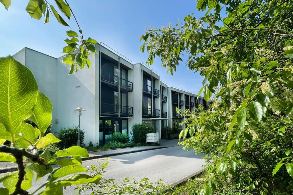 an exterior view of a building with trees at Bildungs- und Tagungshaus Haus Neuland in Bielefeld