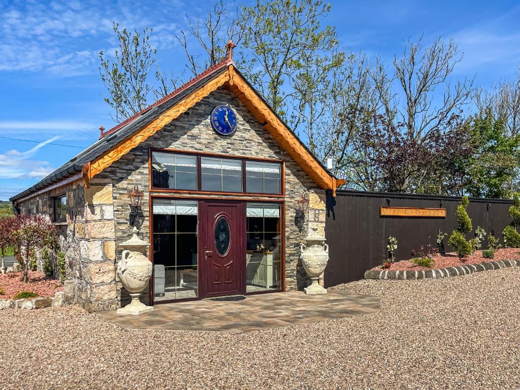 a small stone building with a red door at West Mains Barn - Uk51957 in Kilbirnie