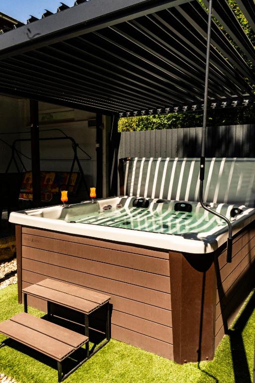 a hot tub with a bench in the grass at Nyugágy Apartman in Gárdony