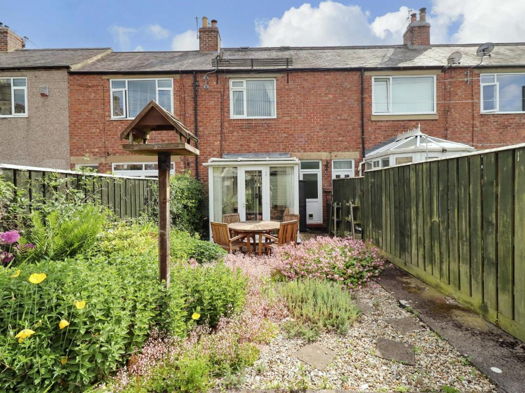 a garden in front of a brick house at Rose Briar Cottage in Morpeth