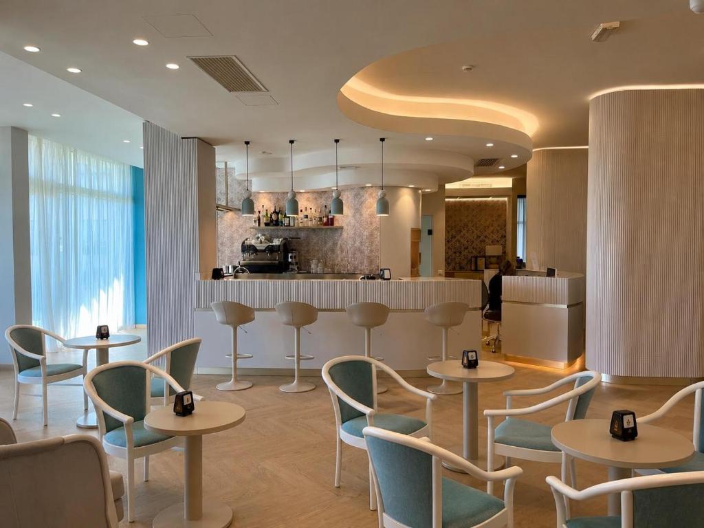 a restaurant with tables and chairs and a kitchen at Residence Hotel Piccadilly in Rimini