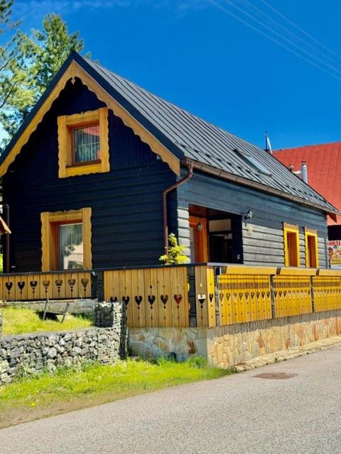 a black house with a fence in front of it at Drevenička U Ježka in Ždiar
