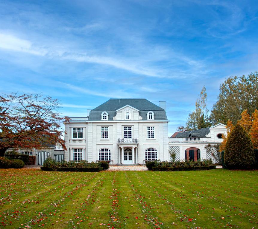 a large white house with a large yard at Castle B&B Castanea in Merelbeke