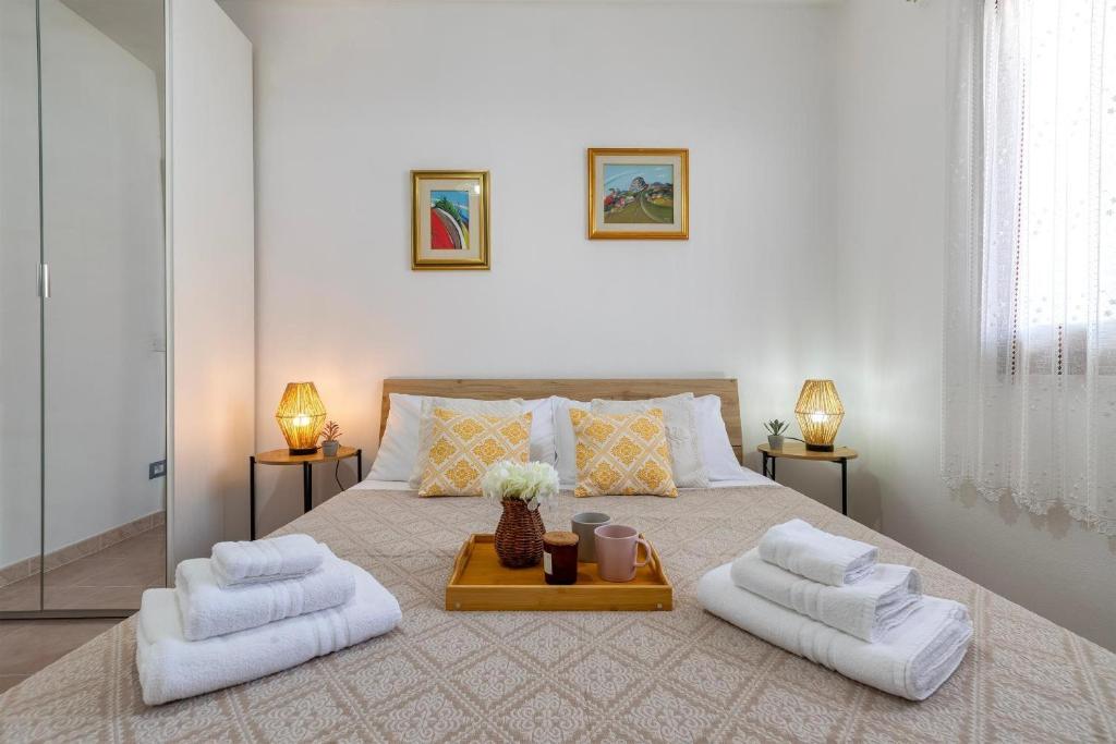 a bedroom with a large bed with two white towels at Appartamenti Da Ewa Valledoria in Valledoria