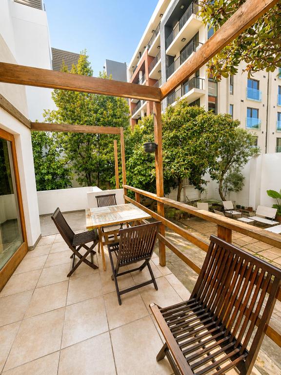 a patio with a table and chairs on a balcony at 12 On Braemar Guesthouse in Cape Town