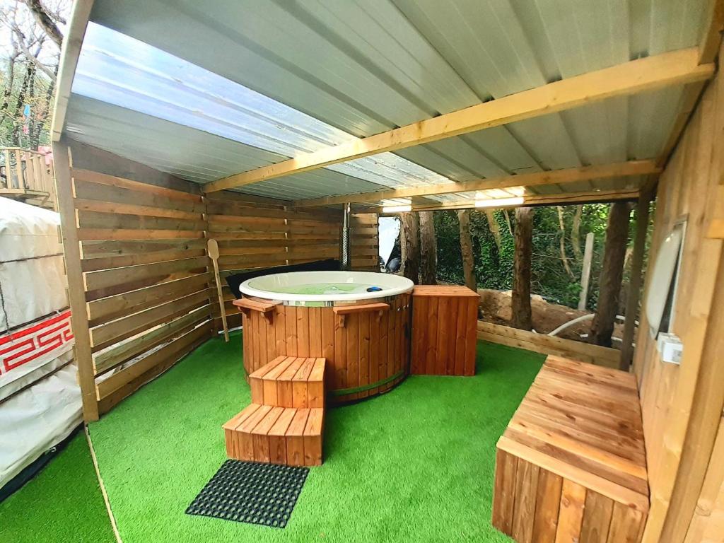 a sauna with a hot tub and two benches at Yourte avec bain nordique in Quimper