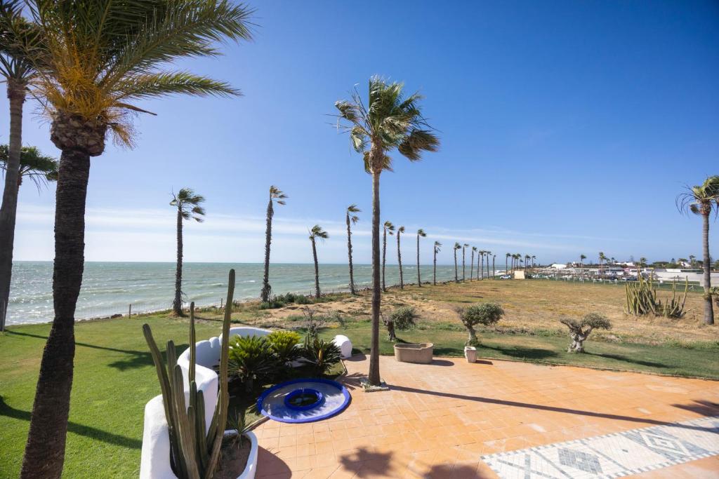 a view of the beach and palm trees at Finca Isla Verde in Chipiona