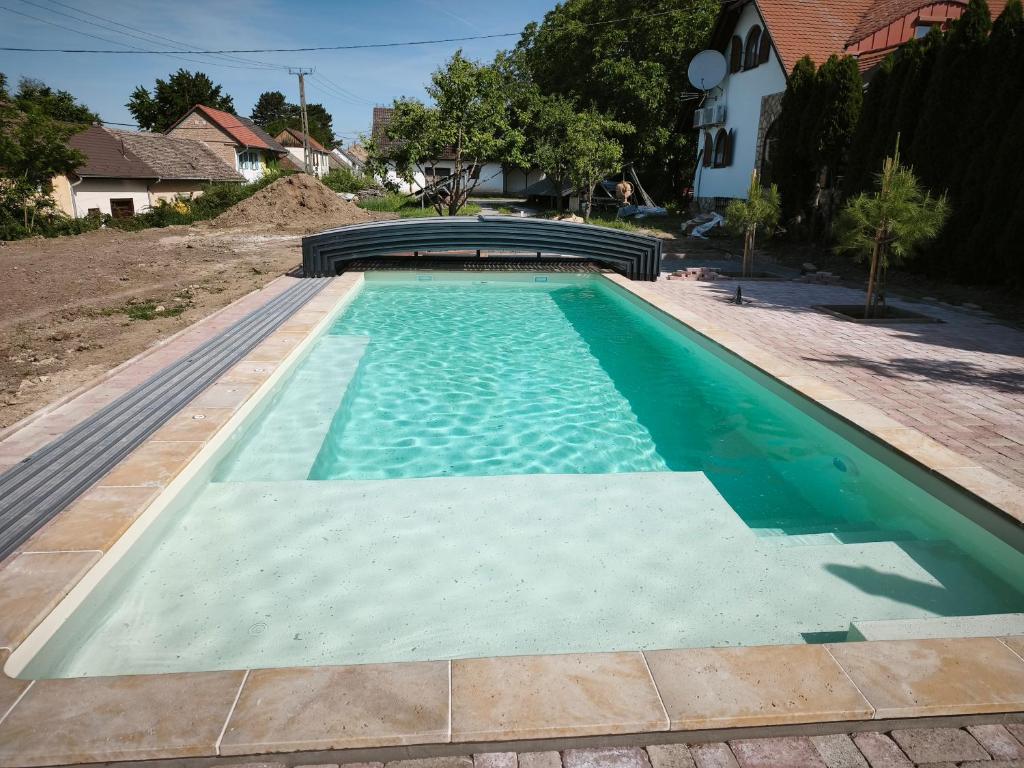 a swimming pool in a yard with a house at Neidhardt Vendégház in Bóly