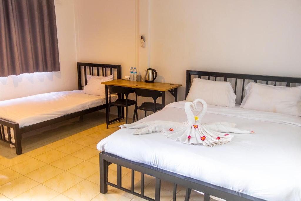 a hotel room with two beds and a table at Patong Canal Villa 308 in Patong Beach