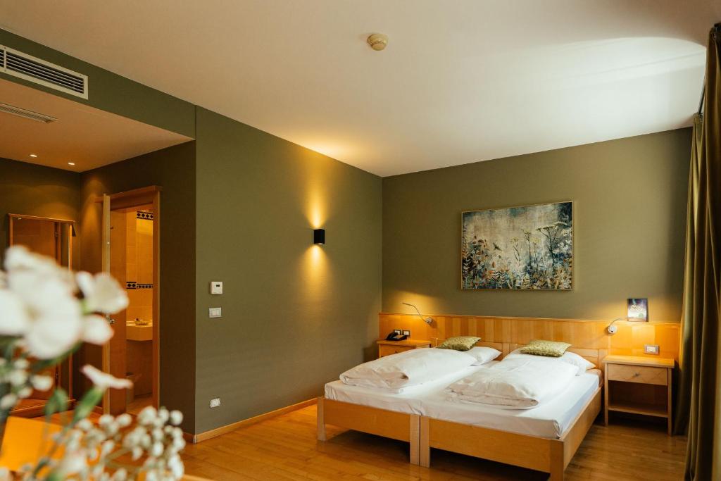 a bedroom with a bed and a painting on the wall at Lodenwirt Residence in Vandoies