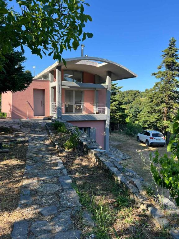 a pink house with a car parked in front of it at Seta Forest House in Séta
