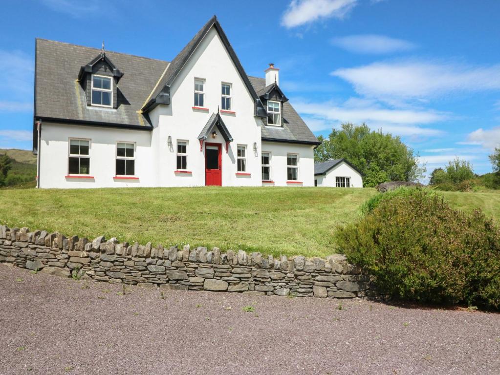 a white house with a red door on a hill at The Skating Rock in Banane Bridge