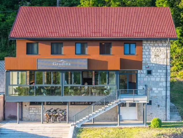 an orange building with bikes parked in front of it at Motel Gradina in Bosansko Grahovo