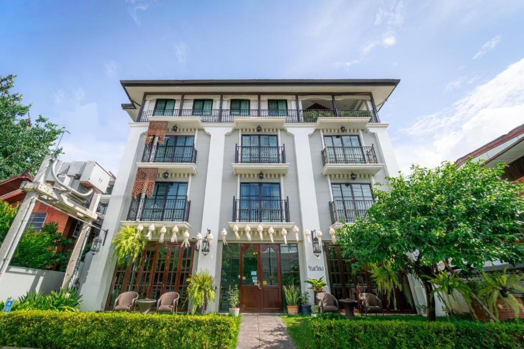 a white building with windows and chairs at Rimwiang in Chiang Mai