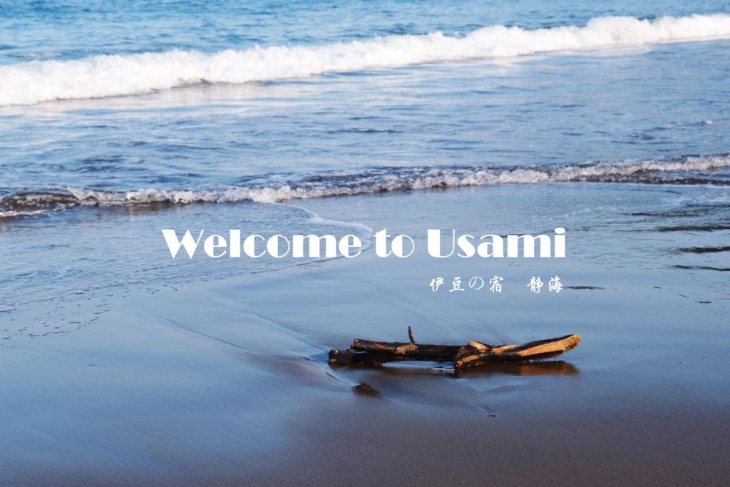 a bottle on the beach with the inscription welcome to usnm at 伊豆の宿　静海 in Ito