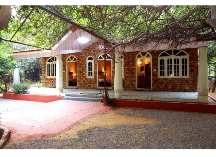 a large brick house with a large window at Ananya Eco Resort in Surūrnagar