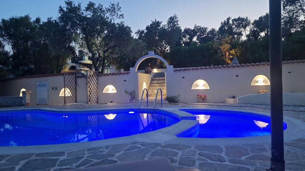 a swimming pool in a backyard at night at Villa in Skiathos in Skiathos