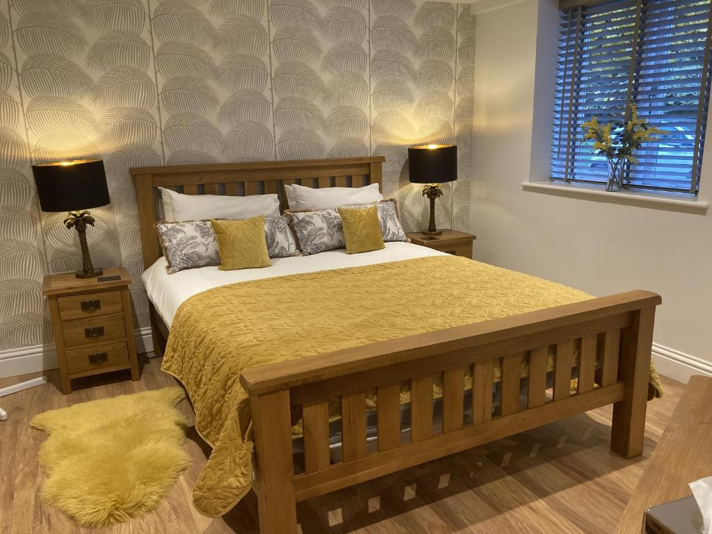 a bedroom with a large bed with a yellow blanket at Streamside Apartments in Yeovil