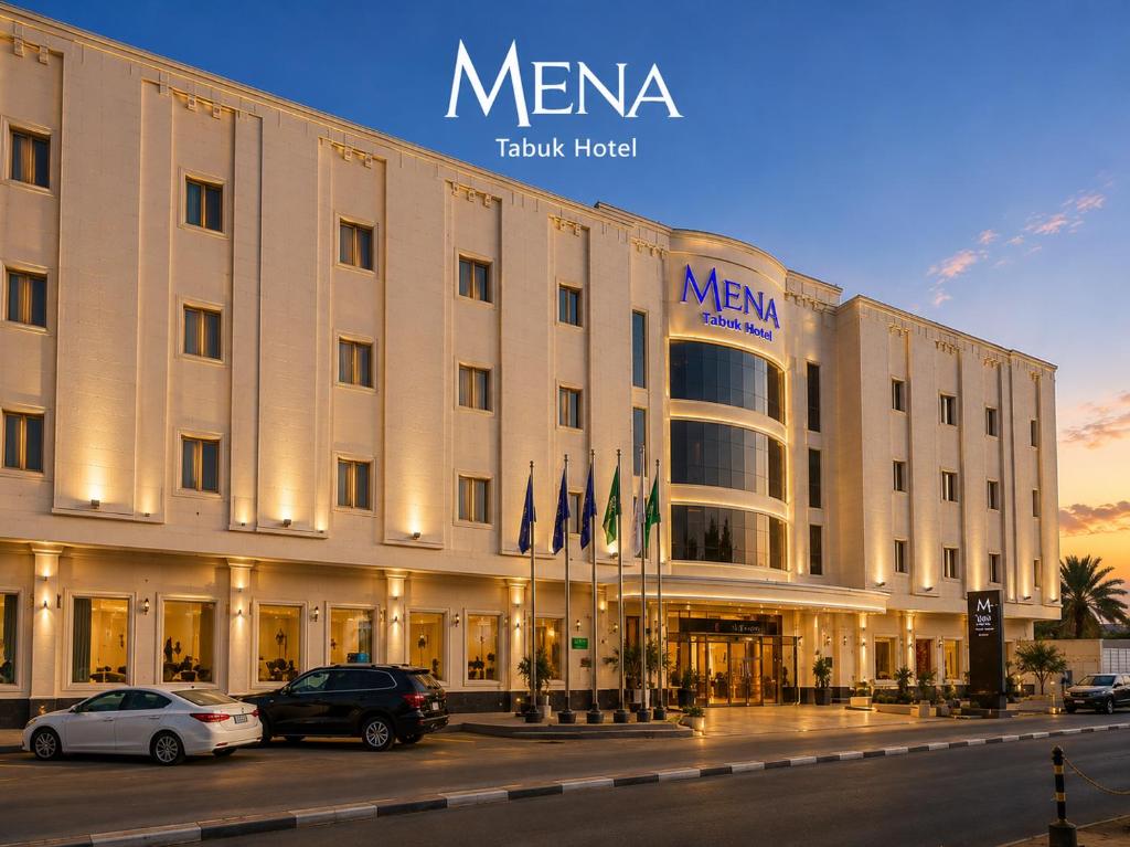 a large hotel with cars parked in front of it at Mena Hotel Tabuk in Tabuk