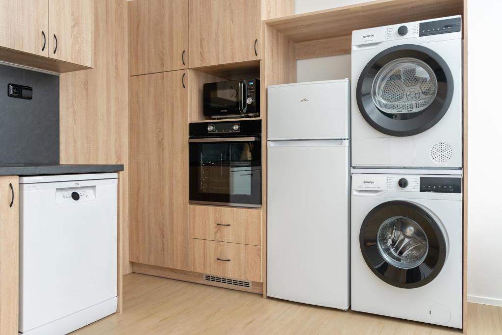 a kitchen with two washers and a washer and dryer at Apartmán nad pilou in Velké Meziříčí