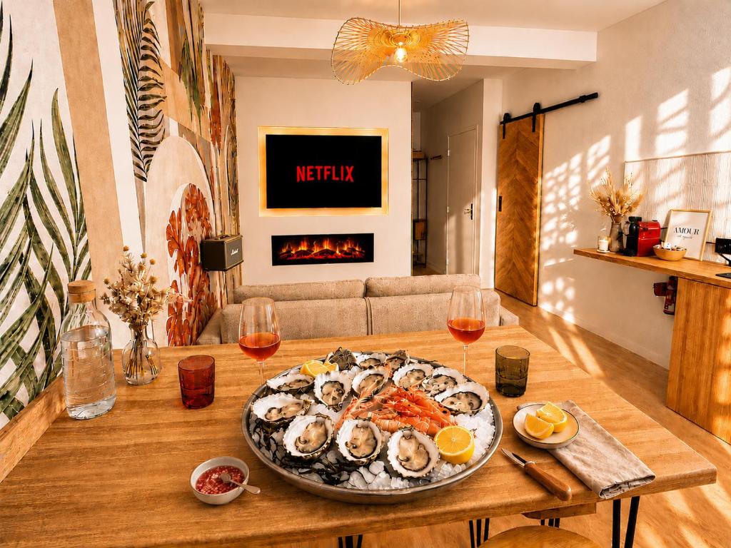 a plate of food on a table in a living room at MRODBNB - Appart Neuf - Aperçu Mer - 25m Plage & Resto - Ciné - cheminée - Popcorn in Cancale