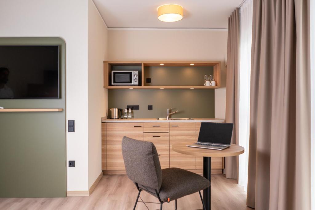 a kitchen with a table with a laptop on it at Hotel Neue Mitte in Schlüchtern