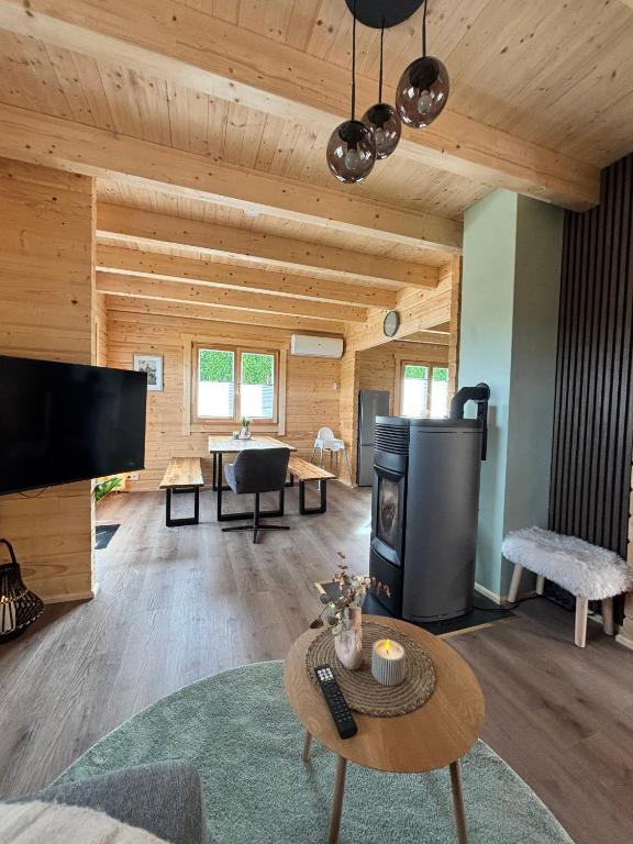 a living room with a fireplace in a log cabin at Modernes Blockhaus mit Sauna Flair in Lisberg