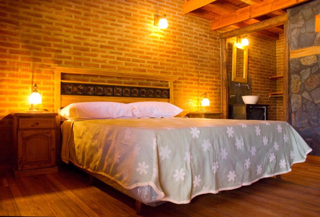 a bedroom with a large bed in a brick wall at Lauquen Pilmaiquen y spa in Merlo