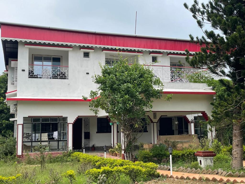 a large white building with a red roof at Jonaki Shantiniketan in Shānti Niketan