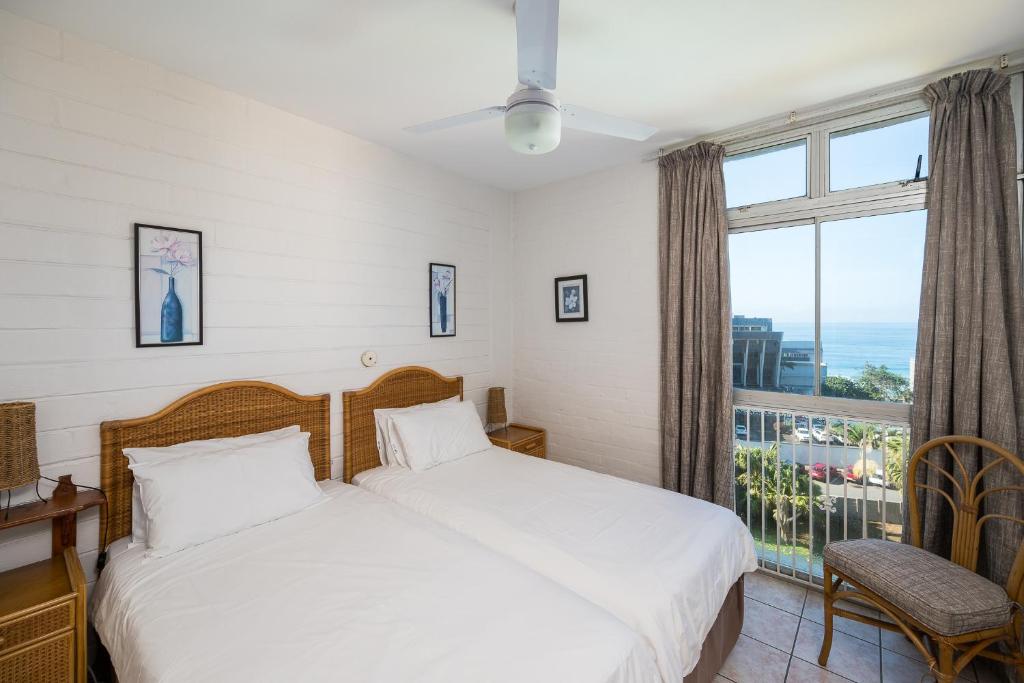 a bedroom with a bed and a large window at La Ballito 402 in Ballito