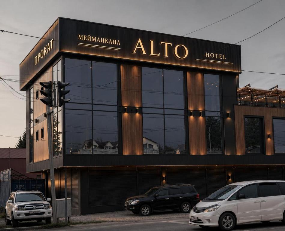 aallo hotel with cars parked in front of it at Hotel Alto in Karakol