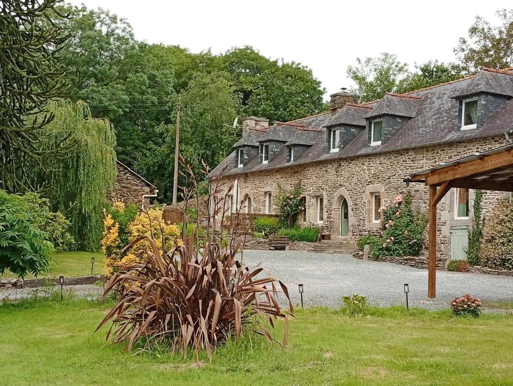 a stone house with a garden in front of it at Bienvenue à Longère Bihan - Chambres d'Hôtes - Bed & Breakfast in Plévin