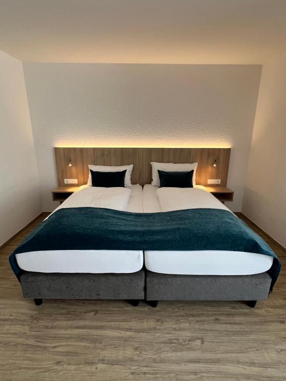 ein Schlafzimmer mit einem großen Bett und zwei Kissen in der Unterkunft Hotel Fantasie in Ansbach