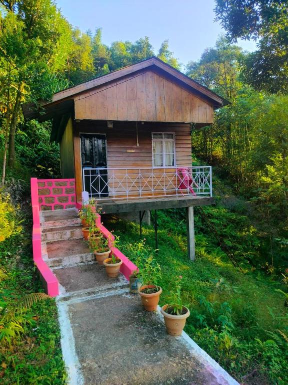 a small house with a staircase in front of it at Hillside Highway Cottages in Shillong