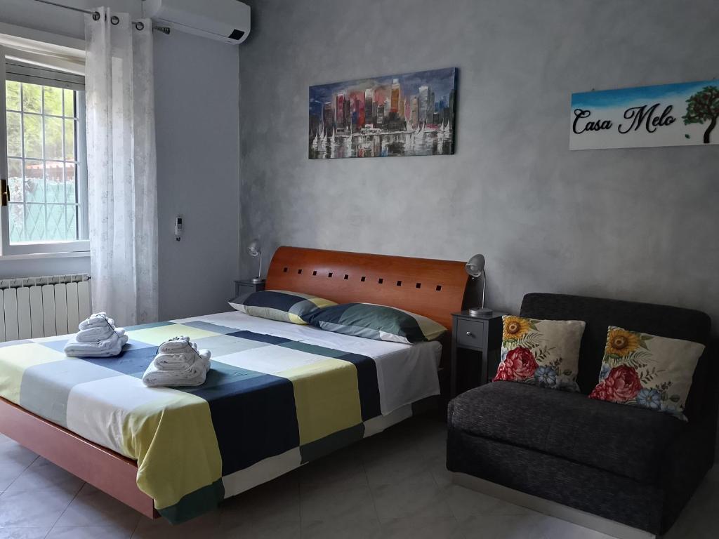 a bedroom with a bed and a chair at Casa Melo in Ciampino