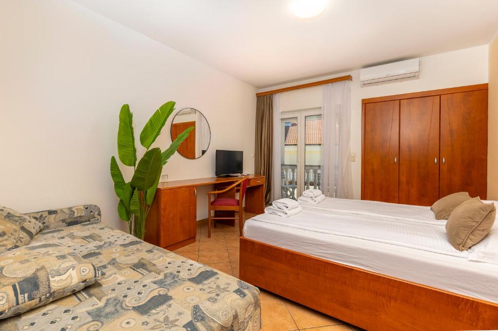 a bedroom with a bed and a chair and a desk at Guesthouse Villa Adria in Malinska