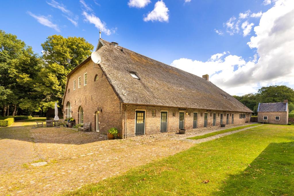 an old brick building with a thatched roof at Appartement Overcinge in Havelte