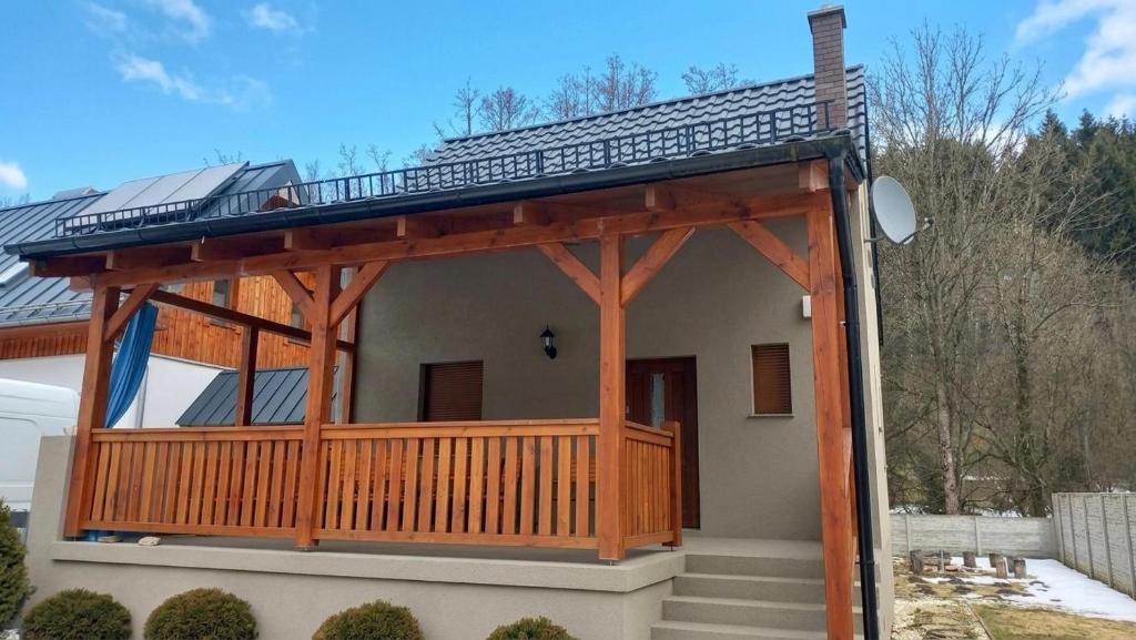 a house with a porch with a roof at Zacisze nad Orlicą in Międzylesie