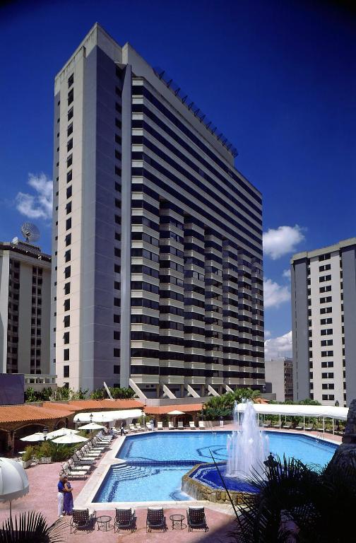 a large building with a swimming pool in front of it at Meliá Caracas in Caracas
