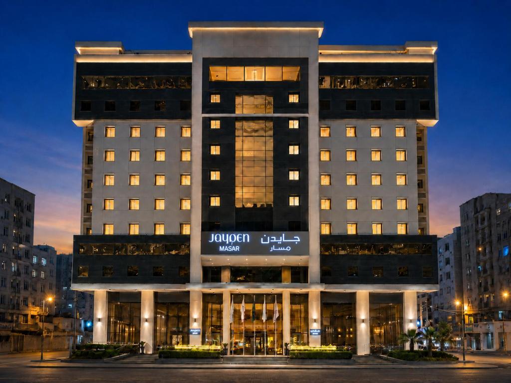 a large building with a sign on it at night at Jayden Masar - جايدن مسار in Mecca