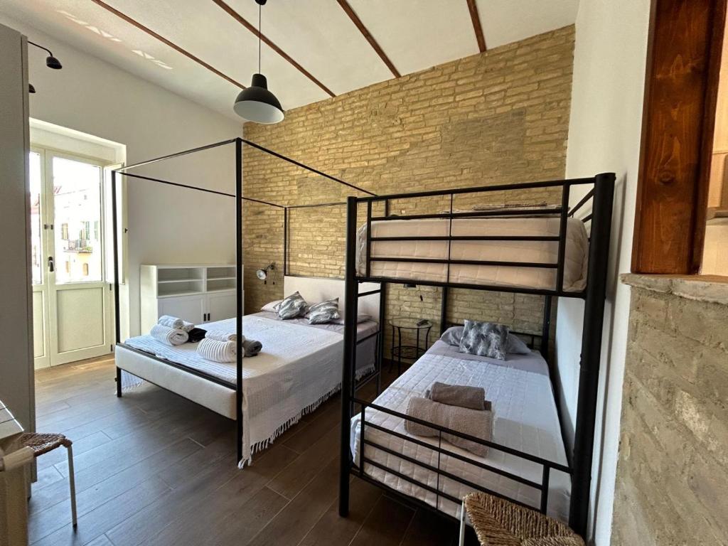 a bedroom with two bunk beds and a brick wall at RELAIS dei TRABOCCHI in Casalbordino