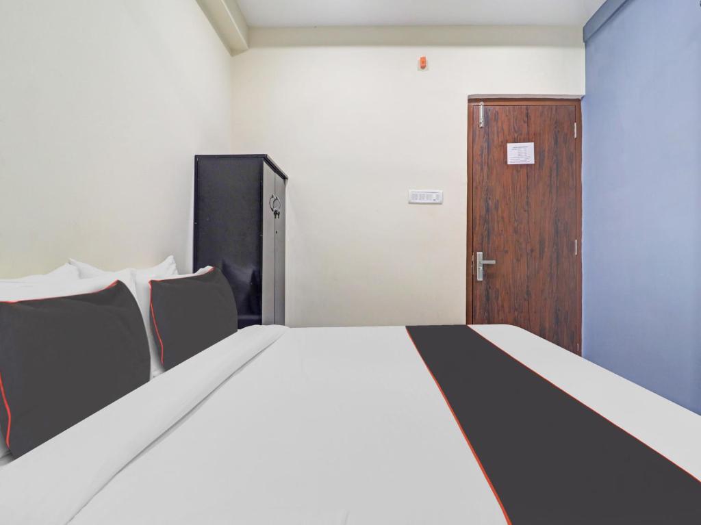 a bedroom with a large bed and a wooden door at HOTEL PNR SUITES KUKATPALLY in Hyderabad