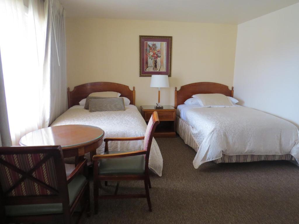 a hotel room with two beds and a table and chair at Laguna Lodge in Marina