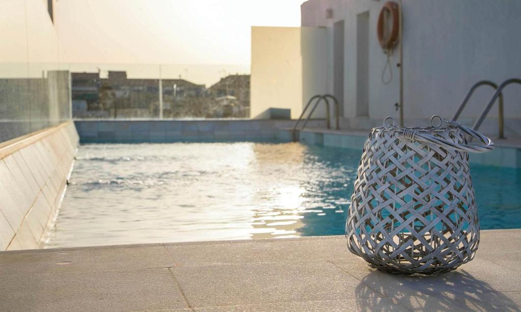 a trash can sitting next to a swimming pool at Hotel Palacio De Úbeda 5 G.L in Úbeda