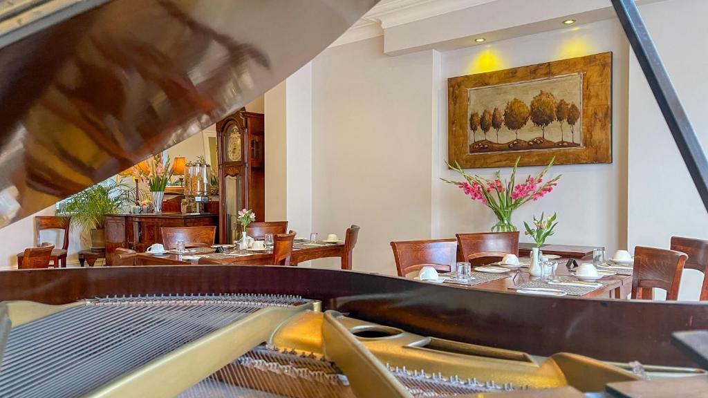 a restaurant with tables and chairs and a piano at The Redstone Guesthouse in Blackpool