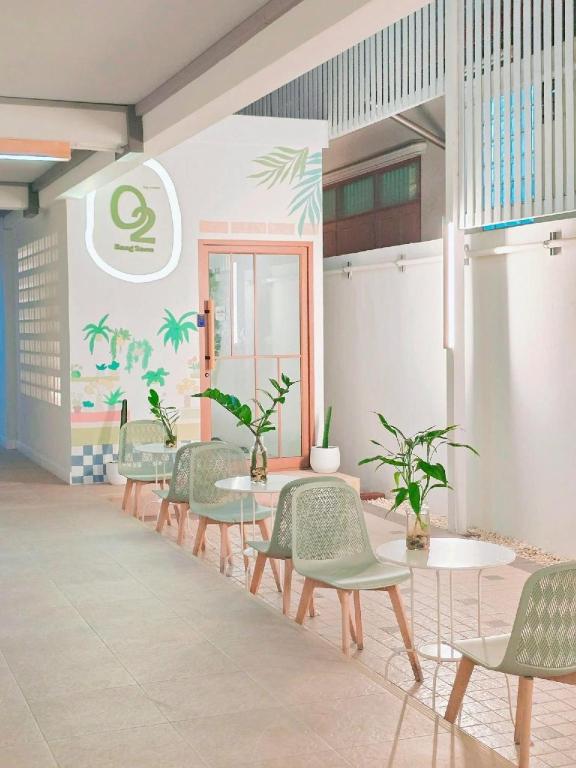 a row of tables and chairs in a room with plants at O2 Bangsaen in Ban Bang Saen (1)