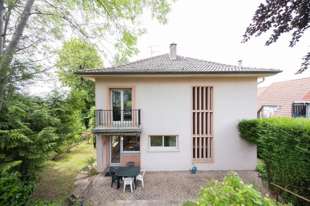 a white house with a balcony and a patio at Maison Bellevue in Brunstatt