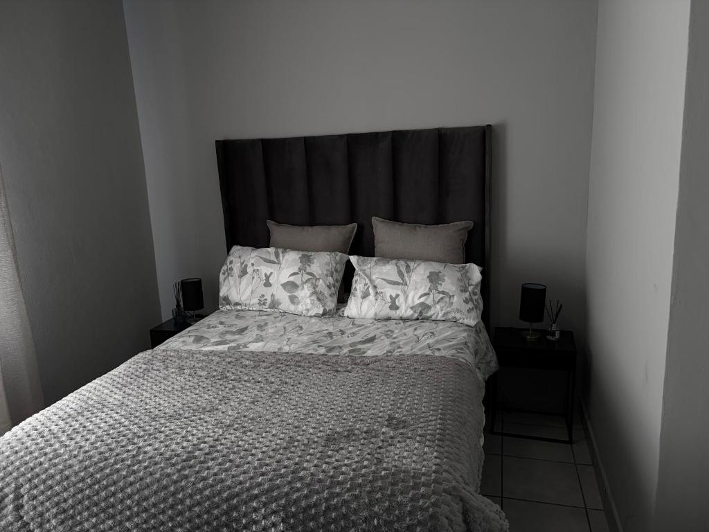 a bedroom with a large bed with a black headboard at Malwandla 1bed full apartment in Centurion