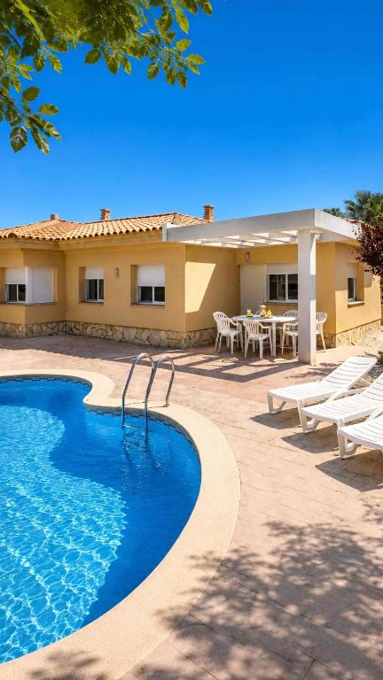 a resort with a swimming pool and tables and chairs at Casa Sastre - "Pet Friendly - Piscina Privada - Playa - BBQ - Parking - Delta de l'Ebre - Riumar" in Riumar