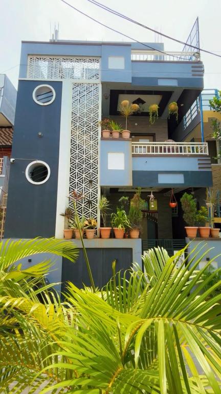 a blue building with plants in front of it at Khushi Homestay Hampi in New Hampi